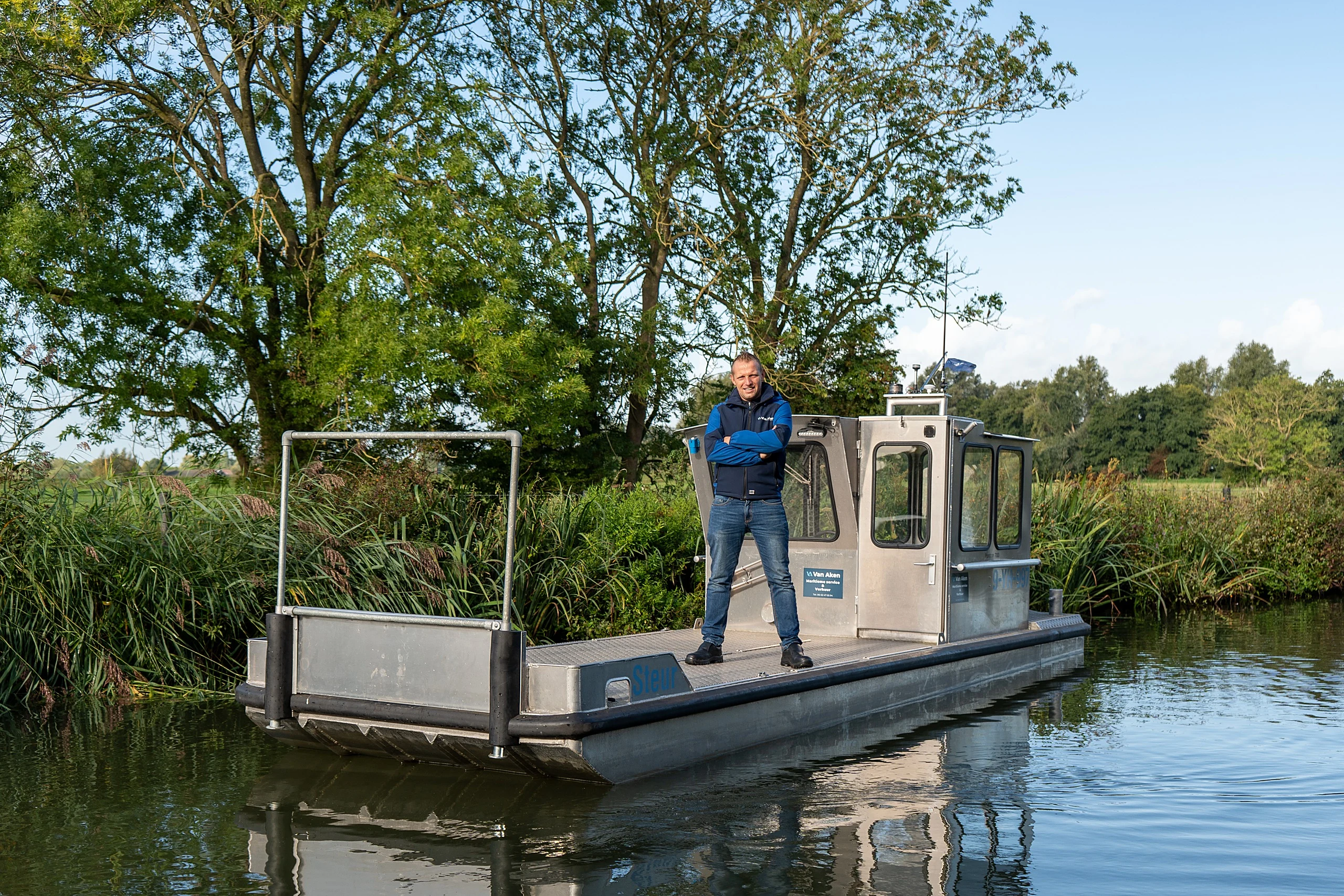 Nico van Aken staat op het open dek van Steur, voor het stuurhuis
